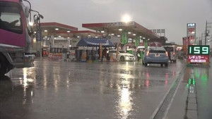 At a Gas Station in a Drenching Downpour